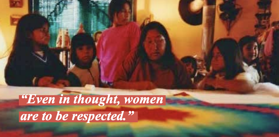 Tillie and her family with a colorful textile displayed in the foreground.