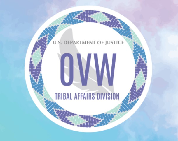 Logo of the U.S. Department of Justice, Office on Violence Against Women, Tribal Affairs Division, featuring a circular, beaded badge with a stylized feather design, set against a pastel-colored background.