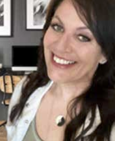 Renee Stapp smiling in an office setting with framed pictures in the background.