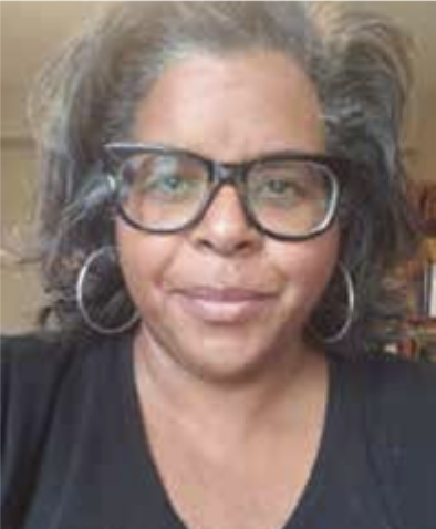 Close-up portrait of Sydney West wearing large glasses and hoop earrings, smiling at the camera.